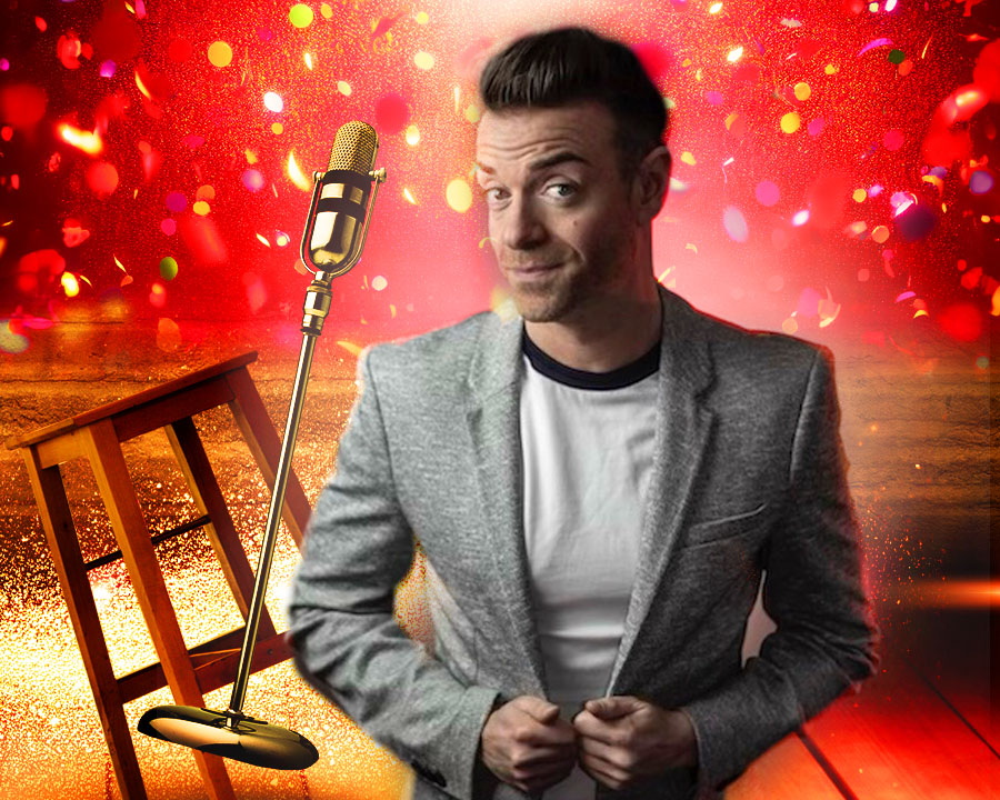 Comedian Des Clarke with confetti and mic behind him